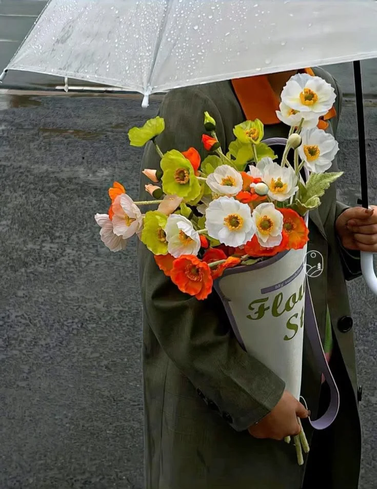 A paper-wrapped bouquet of yellow, white and orange spring flowers.